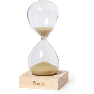 A glass sand timer with a wooden base, featuring a clear design and golden sand, measuring five minutes.