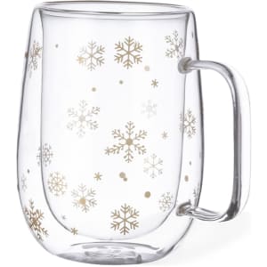A glass mug with a clear design featuring gold snowflakes and a curved handle.