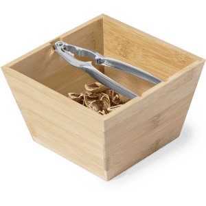 A bamboo nutcracker set featuring a square container filled with nut shells and a stainless steel nutcracker.