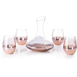 A glass decanter and four matching rose gold gradient wine glasses. The set features elegant, curved designs.