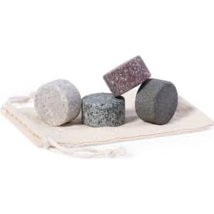 A set of four stone ice cubes in grey, purple, and speckled colour, presented in a natural fabric pouch.