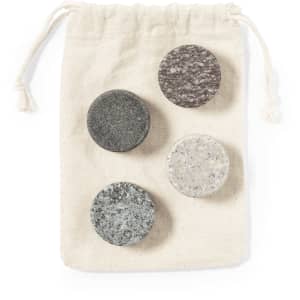 A drawstring bag containing four circular stone ice cubes in grey and white shades.