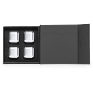 A grey box containing four silver stone ice cubes, presented on black velvet. Includes a logo on the box.