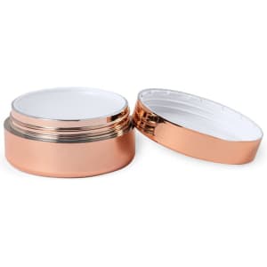 A rose gold lip balm container with a white inner lid, opened to reveal its contents.