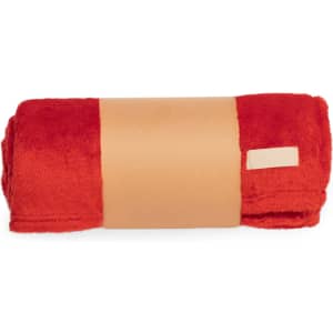 A rolled red blanket with a tan band around the centre, featuring a small logo on the band.