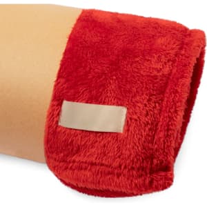 A red plush blanket with a soft texture and a small tag on one edge, rolled up for display.