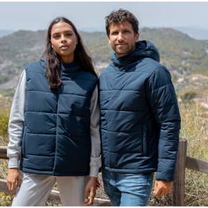 A navy rain jacket with a hood, worn by two people against a scenic backdrop of hills and greenery.