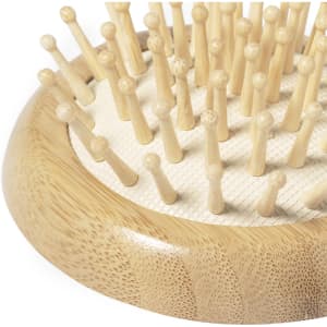 A bamboo hairbrush featuring numerous rounded pins, showcasing a natural colour and a sleek design.