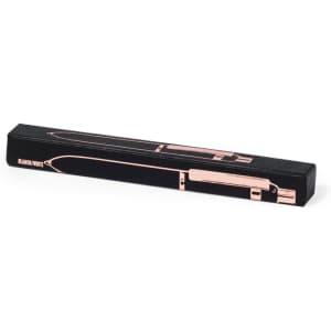 A metal pen in a sleek black and rose gold design, presented in an elongated box with a logo.