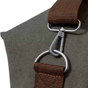 A close-up of a green bag featuring a brown strap and a metal clip attachment. The bag has a textured surface.