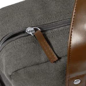 A grey document bag featuring a zipper and a brown leather strap, with a branding logo visible.