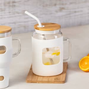 A drink bottle with a white body, bamboo lid, and clear window, featuring a straw and a drink inside.