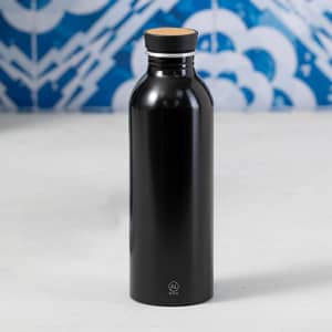 A drink bottle in sleek black with a cork lid and a branding logo at the base.