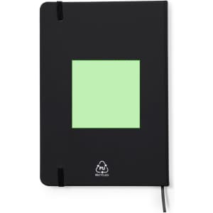 A black notepad with a green square on the front and an elastic closure, made from recycled materials.