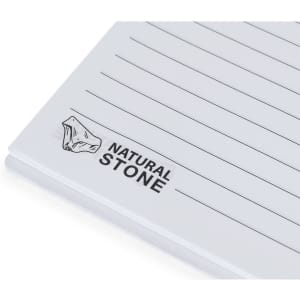 A white notebook with lined pages and a logo featuring a natural stone illustration.