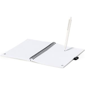 A spiral-bound notebook with white lined pages and a white pen resting on it.