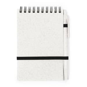 A white spiral-bound notebook with a black elastic strap and a pen attached.