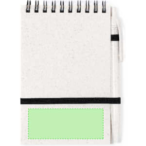 A spiral-bound notebook with a white speckled cover and a green placeholder area, secured with a black elastic band.