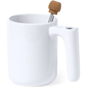A white ceramic mug with a unique handle and a cork-topped stirrer.
