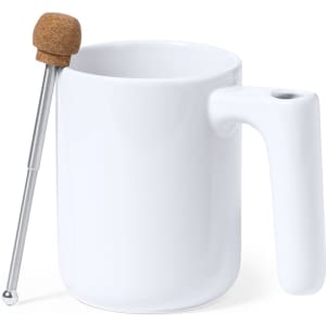 A white ceramic coffee mug features a unique handle and comes with a stainless steel stirrer topped with cork.