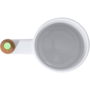 A white coffee mug with a cork accent on the handle, featuring a small green detailing.