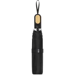 A black umbrella with a wooden handle, featuring a strap and a logo.