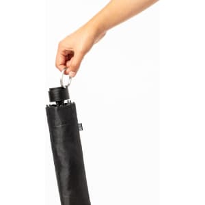 A black umbrella being held by a hand, featuring a metallic ring at the top for attachment.