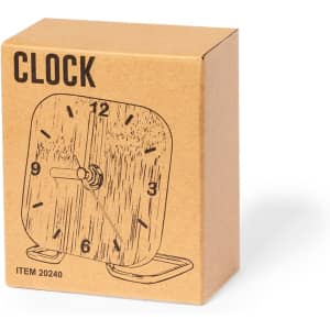 A desk clock in a brown cardboard box with a sketch of the clock design on the front.