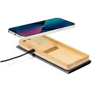 A wireless charger with a bamboo base and grey felt backing, featuring a smartphone positioned above it.
