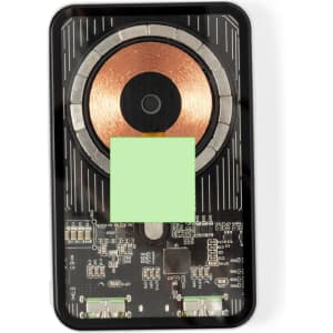 A black power bank with a circular copper charging pad and electronic circuit components visible underneath.