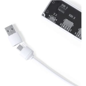 A white USB hub with multiple ports and a white USB cable connected to it. The hub features a logo.