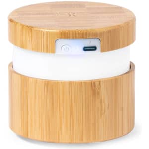 A multifunction lamp with a bamboo exterior, featuring a white light base and a charging port. It's compact and stylish.