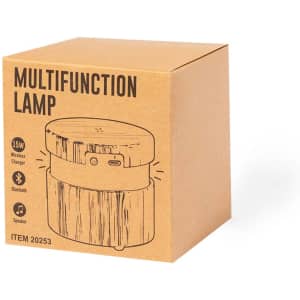 A brown box containing a multifunction lamp, featuring a wireless charger and Bluetooth speaker. The design has a wood-like appearance.