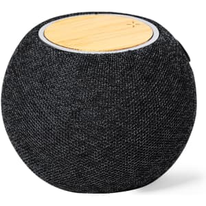 A black fabric speaker with a circular bamboo top and sleek design, featuring a branding logo.