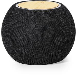 A round speaker with a black fabric exterior and a wooden top, featuring a branding logo.