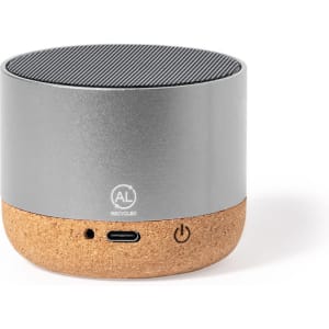 A grey and cork speaker with a textured top surface and a logo on the front. It features USB-C and power buttons.