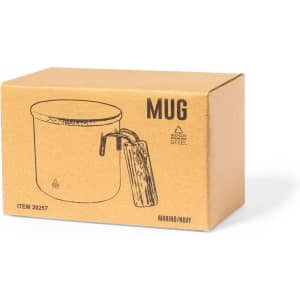A drink mug in a brown cardboard box, featuring a handle and a design in marino and navy colours.