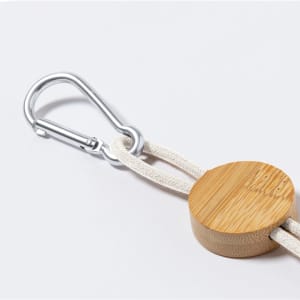 A bamboo keychain with a metal carabiner clip and a soft cord attached.