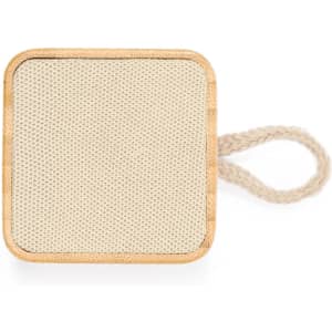 A square beige speaker with a textured surface and a natural wood border, featuring a woven handle.