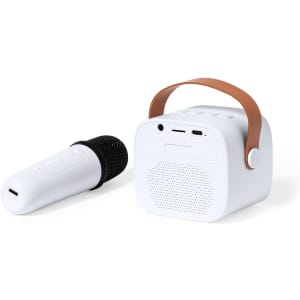 A white karaoke speaker with a brown handle, accompanied by a white microphone. The speaker features ports and a speaker grille.