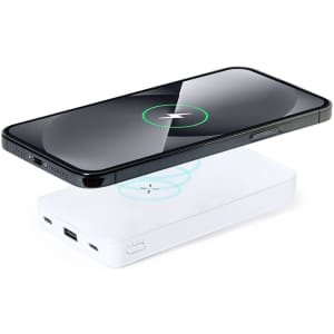 A white power bank with a black smartphone placed above it, displaying a charging indicator.