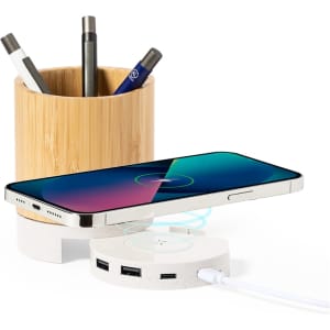 A bamboo pencil holder with pens and a wireless charging pad underneath, featuring multiple USB ports.