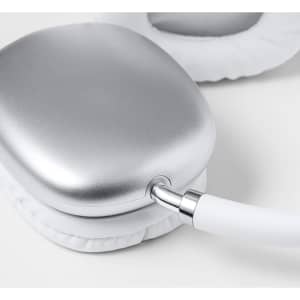 A pair of silver headphones with white padding and a connected cord. The design features a sleek, modern appearance.