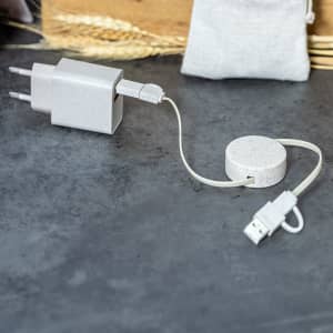 A grey charging adapter with a connected charging cable and a round cable holder. The set includes a logo.