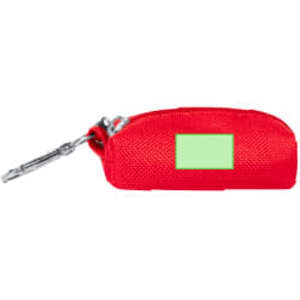 A red waste bag dispenser with a small green label and a metal clip for attachment.
