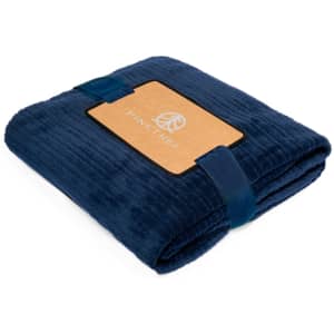 A folded Cindra Blanket in rich navy blue, featuring a branded label and secured with a matching strap.