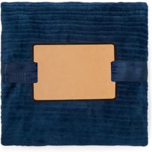 A deep blue Cindra Blanket with a textured surface and a central label area, secured with ribbons.
