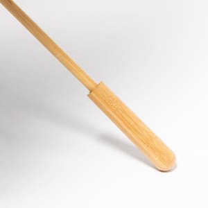 A bamboo shoehorn with a smooth finish and rounded handle, featuring a subtle logo.