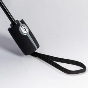 A black umbrella handle with a textured grip and a wrist strap, featuring a silver button and detailing.