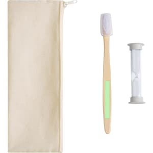 A cream pouch contains a wooden toothbrush, a sand timer, and a pale green accent. The pouch features a logo.